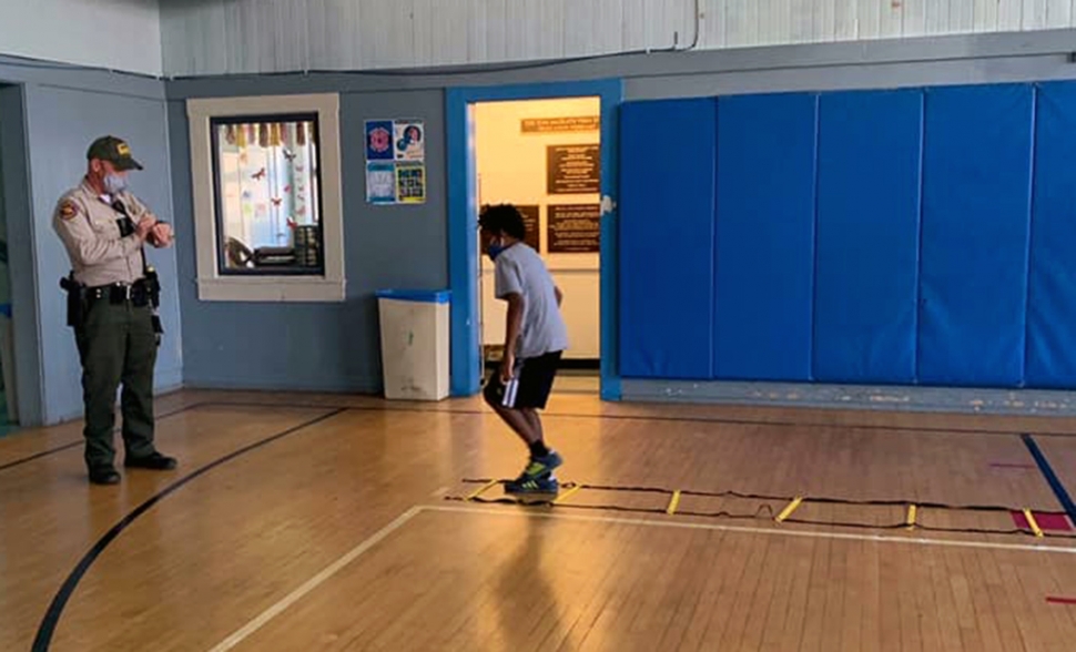 One of the kids running through an agility ladder as Officer Schnereger times him. 