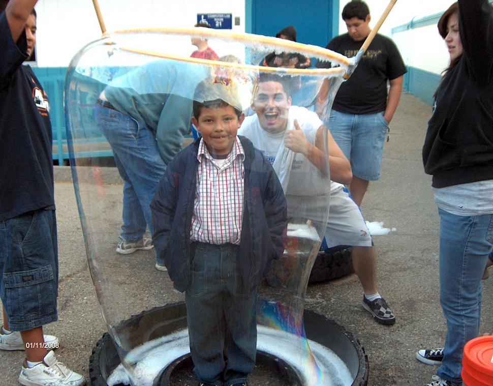 High School community service helper Christian Prado with 1st grader Carlos Rivas. It took them a few times to get Carlos with a full bubble around him.