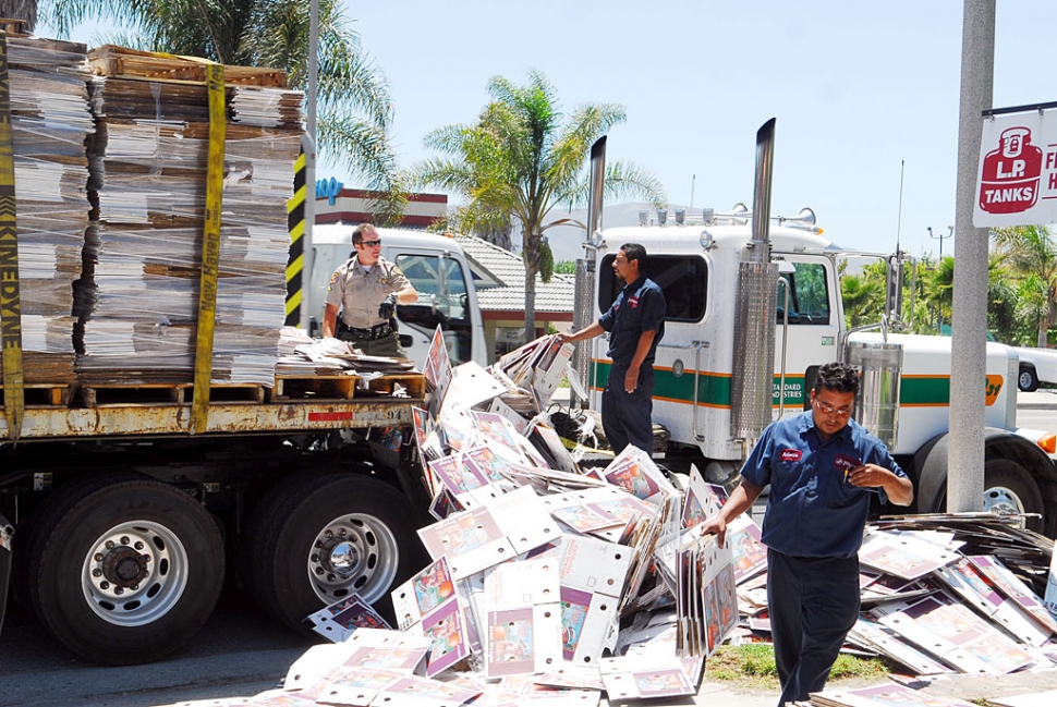 A truckload of cardboard boxes, being hauled by Standard Industires, spilled off this truck last week on Highway 126 at A Street. Officer Biter, left, stopped to help the drivers.