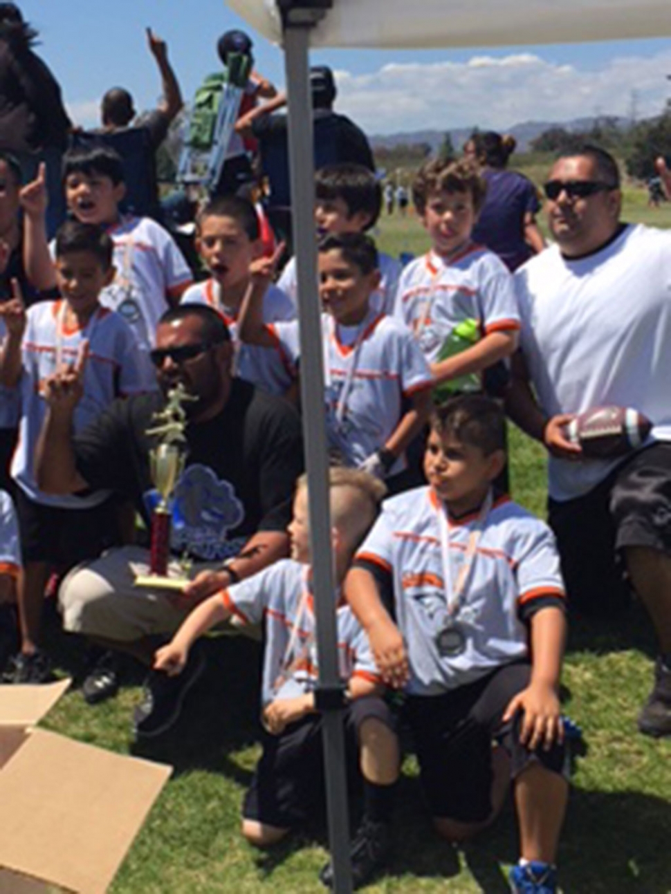The Fillmore Broncos Flag Football team with their coach and trophy after winning division championship against Ventura last Sunday.