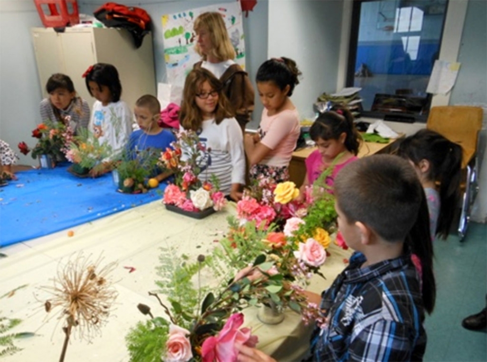 Civic Pride member Cindy Klittich assists at a Boys & Girls Club workshop about entering the flower show and making arrangements.