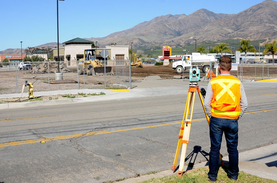 The empty lot located at the southwest corner of Highway 126 and C Street has been fenced in, preparing for new construction. Pictured is a surveyor watching the work being done. 