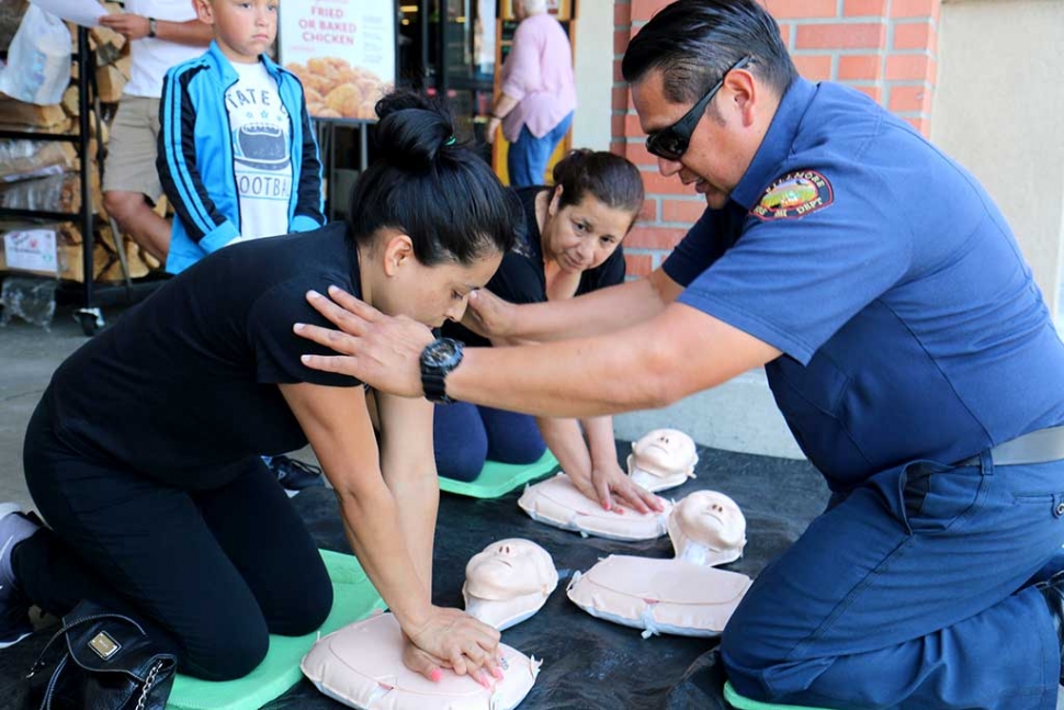 Fillmore Fire Department had a wonderful turnout of over 80 individuals who participated in the Hands Only CPR event in front of Vons on the 600 block of Ventura Street Thursday, June 2nd. By teaching community members Hands-Only CPR, more victims of sudden cardiac arrests will have bystander performed CPR and will be more likely to survive. Customers who were approached and invited to participate were instructed on proper steps to Hands Only CPR. They were taught to check for responsiveness: shaking and shouting “Are you okay?”: followed by calling 911 or having someone else do so if the individual is unresponsive and breathing slowly or not at all. Compress: Position on the floor face up. Kneel right next to the person - so your knees touch his/her arm. Place the heel of one hand on the center of the chest at the sternum and the other hand on top of the first. Lock your elbows put your shoulders over the center of the chest and push HARD straight downward - at least 2 inches. Lift your hands off the chest slightly after each compression to allow the chest to fully re-expand. Compress fast at a rate of 100 per minute. Continue until EMS arrives. Don’t stop if the person gasps it is not a sign of recovery - it’s because you are doing a good job with CPR. When you tire switch off with other people. Many people are concerned they might do something wrong, but the only way to make things worse is by doing nothing. Some of the participants had expressed past experiences where this would have been helpful and possibly life saving for their friends and family members. This event proved to be very well received and appreciated by the community. Pictured is Firefighter David Biazon. Photo courtesy Sebastian Ramirez.