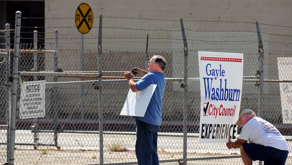 Council candidate Jamey Brooks and his Campaign Manager/Life Coach Gary Creagle posting unauthorized campaign signs last week. The property owner’s posted sign is ignored.