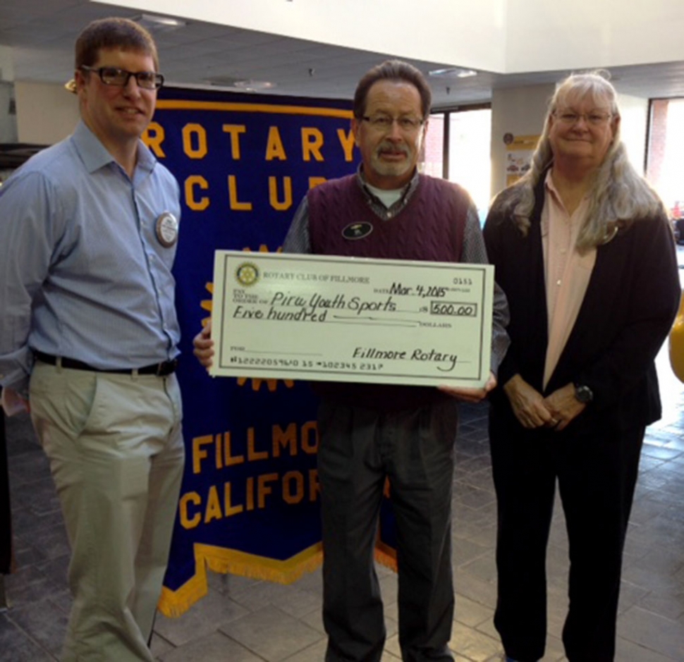 Gilbert Escoto accepted a check for Piru Youth Sports from Fillmore Rotary Club’s Sean Morris and Cindy Blatt.