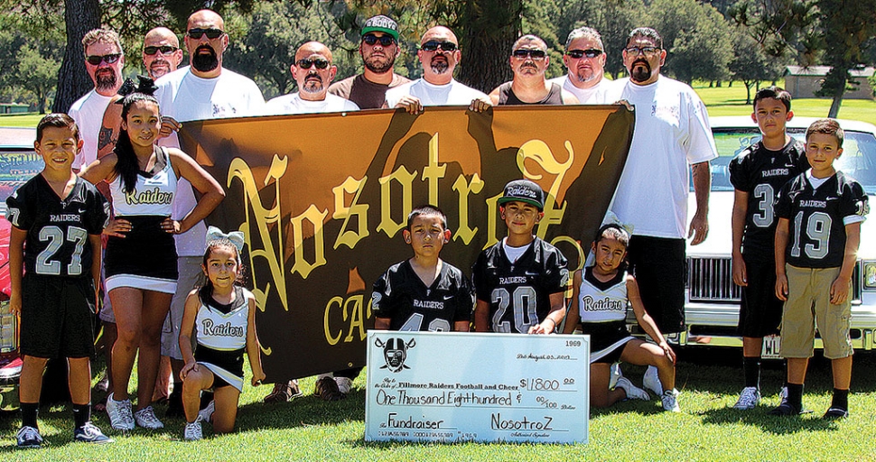 On August 3rd the Nosotroz Car Club presented athlete participants of Fillmore Youth Football & Cheer with a generous check donation of $1800 from a barbecue dinner fundraiser which was held back on June 29th, 2019. Funds will be used by the organization to ensure the safest of equipment for its participants as well as field fees for practicing and hosting of local games. The Fillmore Raiders Youth Football & Cheer would like to express their overwhelming appreciation for the continuous support of the Nosotroz Car Club. Additional recognition and appreciation to our local restaurants for their donations/contributions: El Pescador, Brenda’s Casamia, La Fondita and La Michoacana. Pictured above is the Nosotroz Club with some the Fillmore Raiders Youth Football and Cheer participants. Photo courtesy Crystal Gurrola, information courtesy Fillmore Raiders Youth Football and Cheer.