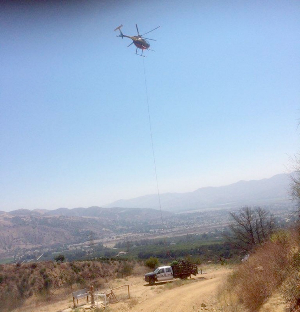 A helicopter loading some of the seized contraband onto a Sheriff ’s vehicle.