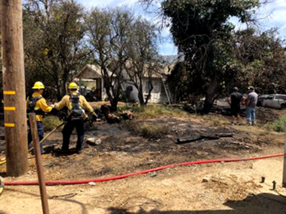 On Saturday, August 3, just after 1 p.m., a vegetation fire broke out at Howe Road and Highway 126. Piru Engine 28 could see smoke about a mile out; once on scene firefighters found a 100 x 100 foot fire surrounding a small farm house. Crews stopped the fire before it could reach the house, however at least one vehicle was damaged by flames. No injuries were reported; cause of the fire is still under investigation. Photos courtesy Ventura County Fire Department.