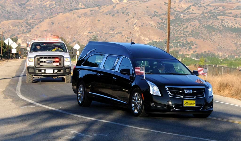 A procession left Fillmore for Ventura on Thursday afternoon with the body of Cal Fire Engineer Cory Iverson, 32, of San
Diego. Iverson was killed in the Thomas Fire in the mountains above Fillmore by thermal injuries and smoke inhalation. Iverson leaves a wife, a 2-year old daughter and a daughter due in May. About a dozen people waited on Highway 126 at Old Telegraph Road with flags to express their gratitude and sorrow as Iverson’s hearse passed by. Every freeway overpass between Fillmore and Ventura was stationed with a fire engine with the American flag flown on the ladder. Citizens waited along the roads and the on the overpasses to pay tribute to Iverson during the 25 mile drive. A Gofundme page has been setup to help the family at https://www.gofundme.com/nmkkc-for-ashley-iverson-and-her-girls
