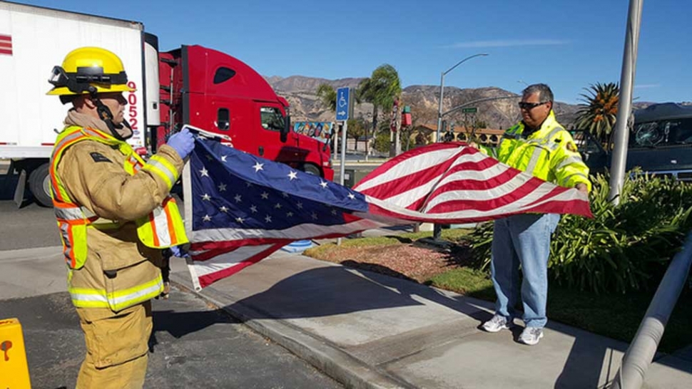 Chief Landeros took time at the scene of a car accident to fold the American Flag at McDonalds.