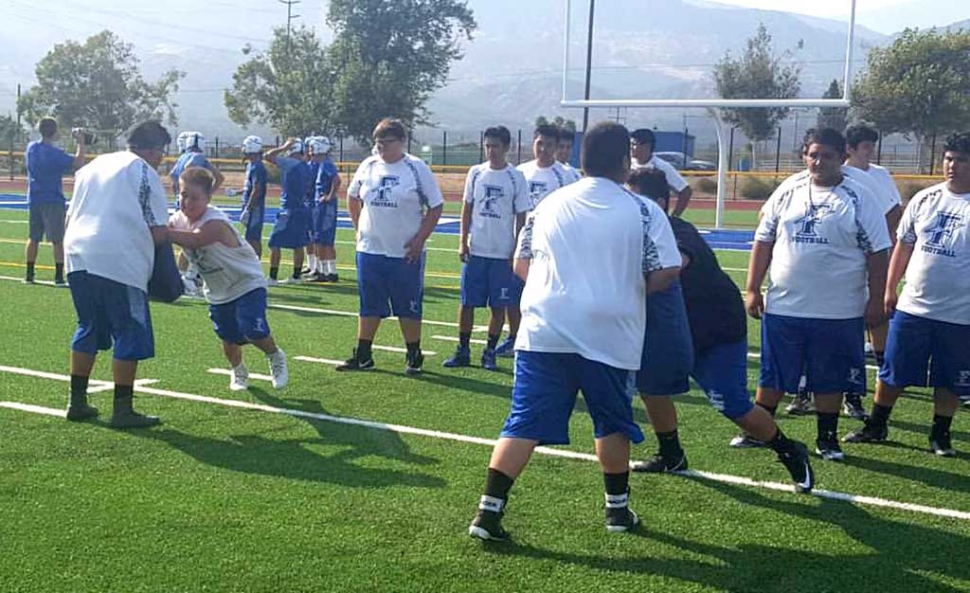 Fillmore High School JV and Varsity Football teams preparing for the upcoming season. They were seen going through wide base, head up, and short choppy steps drills together.