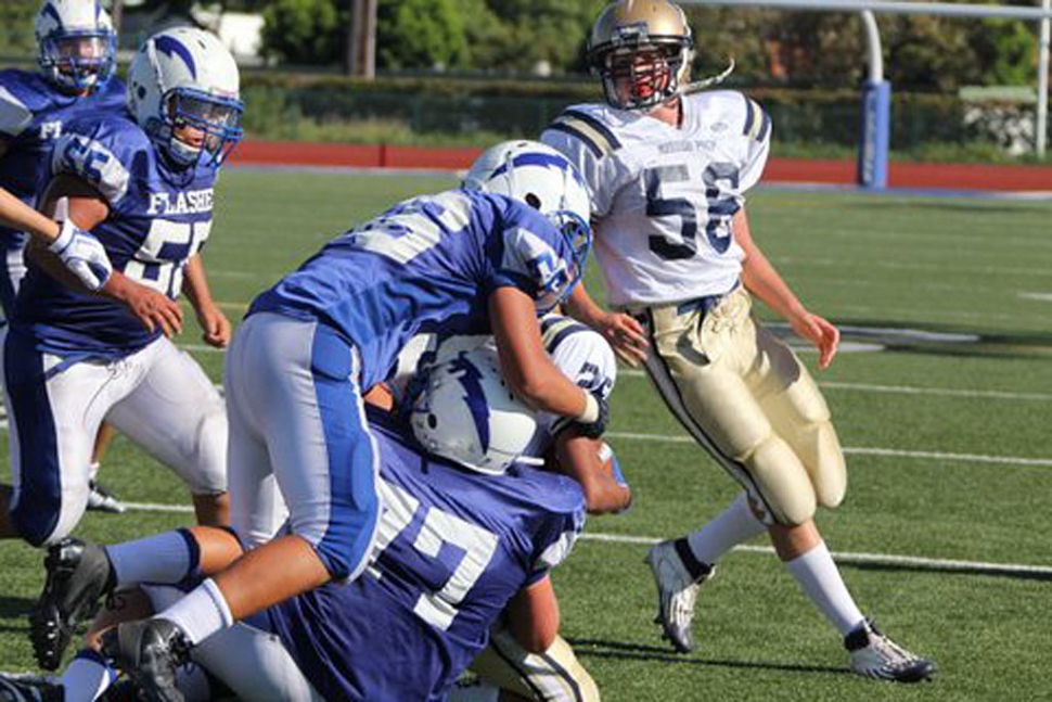 Fillmore Flashes JV players David Cadena #26 and Chad Petuoglu #77 tackle Mission Prep’s runner.