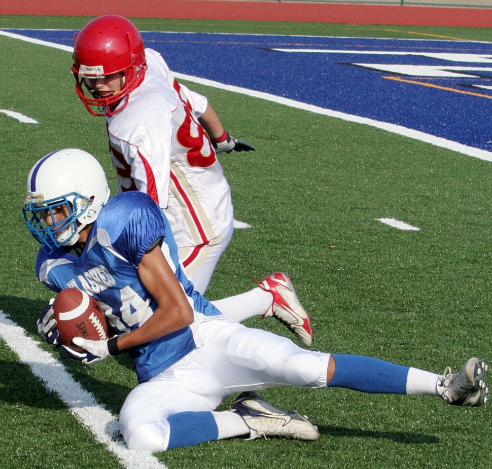 J.V. Offense played great, beating Village Christian 32-0. Here a player catches a ball that was thrown low, before it hit the ground. JV Football Re-cap: Ty Casey & Johnny Golson ran the ball well on offense both with
numerous long runs--Johnny also had a nice pass for 35yrds on a trick play. RB Austin Davis also ran the ball well scoring two touchdowns. QB Corey Cole threw the ball well completing 5 of 6 passes for 125yrds. He also scored on a quarterback sneak. Angel Barrajas scored our first touchdown on a great hard run breaking four tackles & running for 45yrds to score. Derek Luna & Benny Garcia played well on def & 95lb Robert Bonilla made a great hard tackle on the kickoff team. Score was 32 to 0.