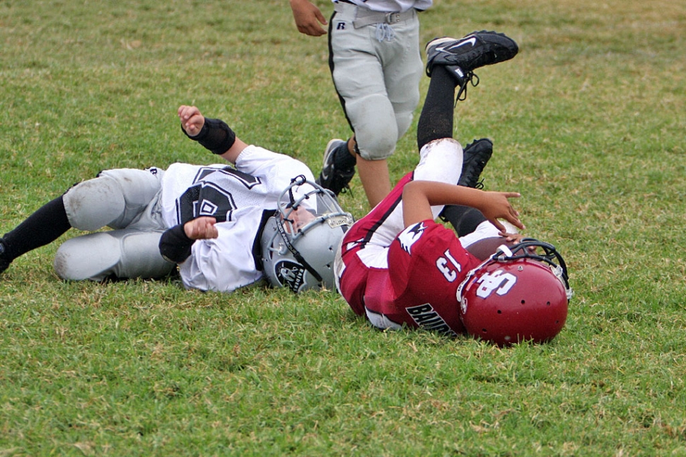 An Unidentified Raider Defender takes down a Cardinal Ball carrier