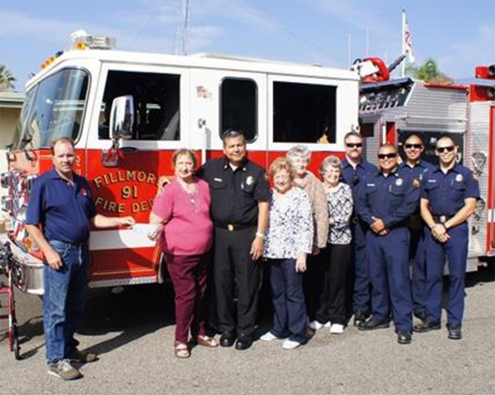 Scott Beylik of FVFF and Jeanne Klittich of FWSC holding check presented to the Foundation. Attending are Fire Chief Rigo Landeros, several of his personnel and Club members Marilyn Griffin, Donna Voelker and Tobey Bowers.