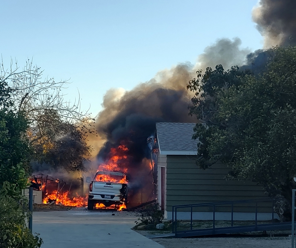 On Saturday, December 24th, at 2:23pm, Fillmore Fire Department and Ventura County Fire were dispatched to a reported structure fire in the 900 block of Bridge Street, off Grand Avenue. Before crews arrived at the scene a plum of black smoke could be seen from north Fillmore. Arriving firefighters reported a detached garage fully engulfed and crews requested to upgrade it to a working fire. Firefighters were able to knock down the fire within 30 minutes. A fire investigator, along with SoCal Edison, was requested to respond. No injuries were reported at the time of the incident. The cause of the fire is
under investigation. Photo credit Russ Avison, Canine Logic. 