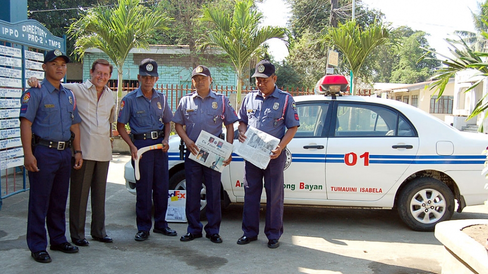 Photo of John at the Tumauini police station with 4 of his officer friends.
