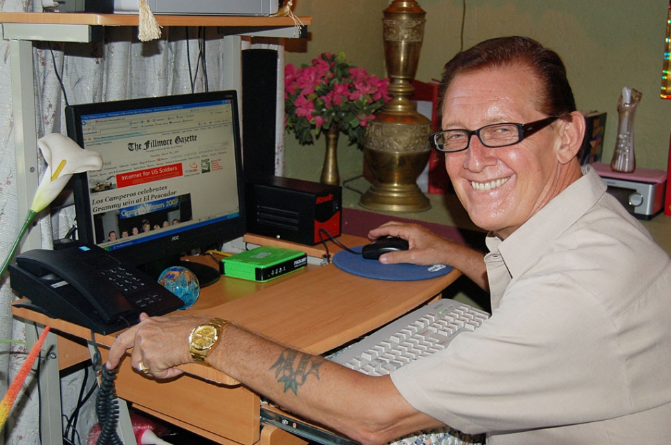 John at home in front of the computer.
