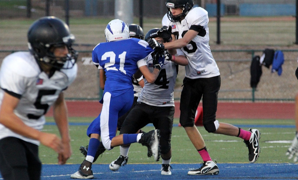 #21 Dylan Satterfield wards off two defenders to make the tackle