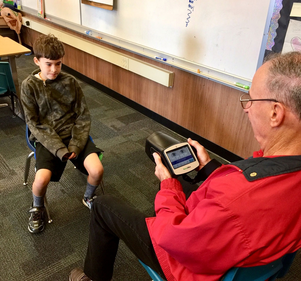 1,000 children at six schools for vision problems. Vision screening has been a part of Lions Clubs International’s mission since its founding and continues today. (Above) Pleasant Valley Club Past President Tom Debardas screens San Cayetano School student Casey Spore. Photo courtesy Brian Wilson.