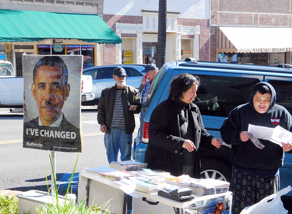 Lyndon LaRouche supporters were in front of the Fillmore Post Office last week handing out the movement’s controversial material. LaRouche was sentenced to 15 years imprisonment in 1988 for conspiracy to commit mail fraud and tax code violations, but continued his political activities from behind bars until his release in 1994 on parole. Also shown is a picture of President Barack Obama with a Hitler-like mustache, which is typical visual rhetoric with the LaRouche Movement.