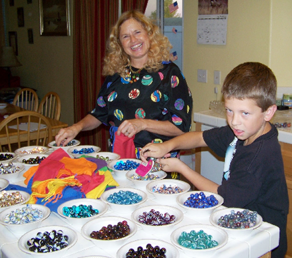 “The Marble Lady” (Cathy Runyan) helps Luke Myers bag over 13,000 marbles for the fundraiser.