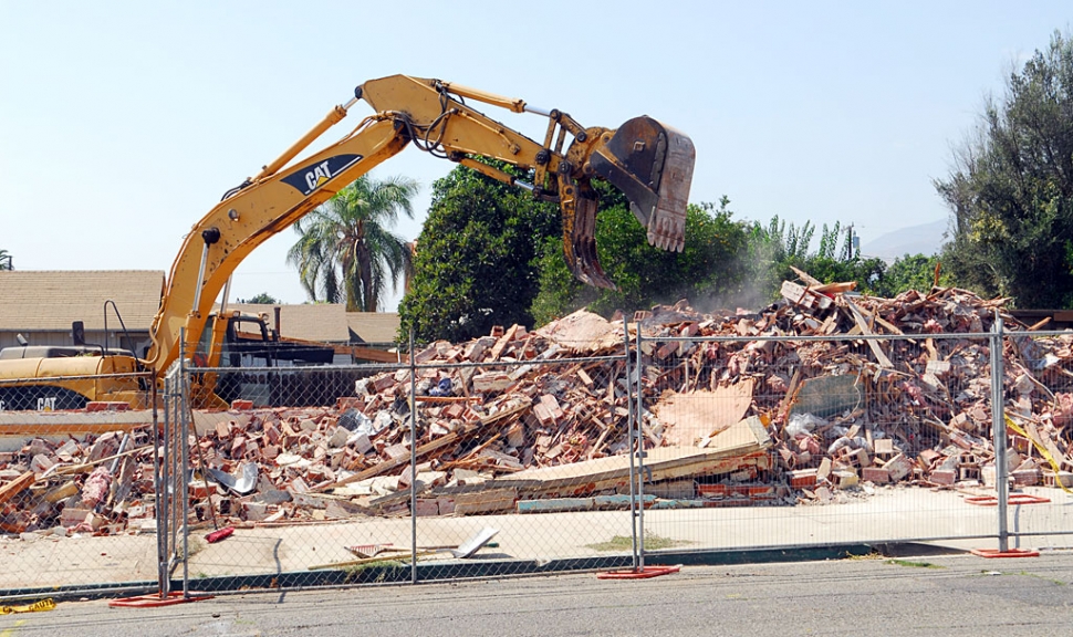 Like the giant toy claw crane waiting to grab a prize, the bucket scoops down on Richard’s Meat Market, which has been closed since the 1994 earthquake.