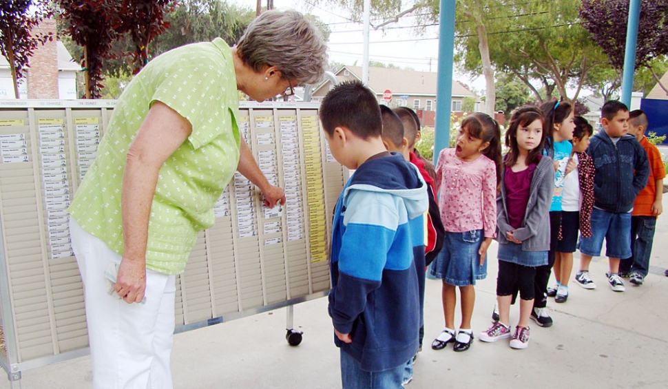 Ruth Ricards, Director of Child Nutrition for Fillmore Unified School District, is showing San Cayetano students how to find their name for their lunch scan card. There is a new technology scanning system in the elementary schools this year. The students find their teacher, find their own name on a card, then scan it and proceed to lunch. It appears that the students enjoy looking for their own card.