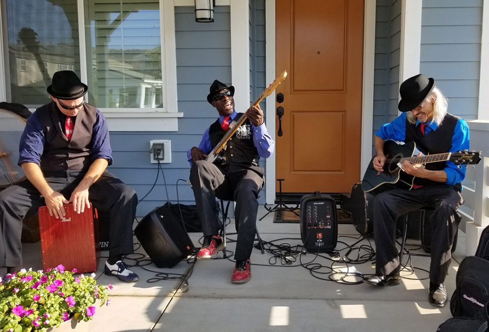 On Saturday, August 4th from 5pm – 7pm the Bridges subdivision, located east of Rio Vista Elementary School, hosted Fillmore’s first ever Porch Fest. This was an event that celebrated music and community. The event was an open invitation to whoever wanted to drop by and enjoy the live music performed on front porches, yards or driveways within The Bridges subdivision. The “All Digital String Band” preformed traditional Bluegrass with highlight performances from local Fillmore musicians. A notable local blues festival favorite “Kingfish” (pictured above center) also stopped by for a short cameo acoustic performance. Kingfish is a favorite at the Long Beach Blues Extravaganza where he performs with his band The Other Mules.