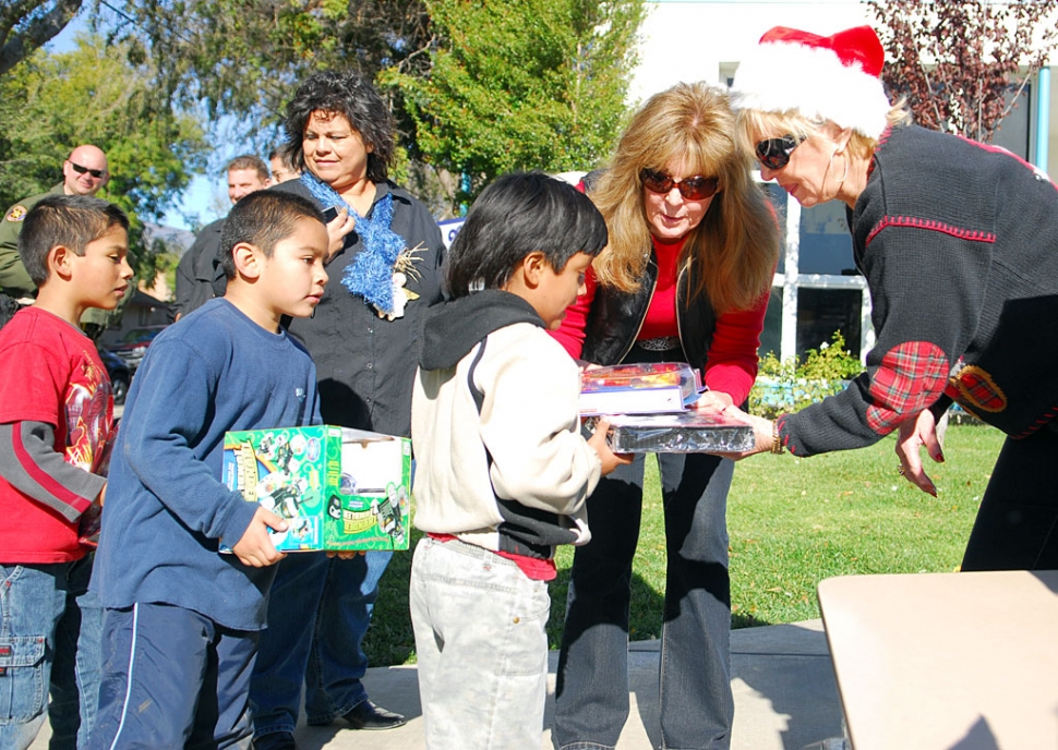 On Tuesday and Wednesday, December 17 & 18, “Support For The Kids Foundation” handed out hundreds of Christmas gifts to every student at Piru and San Cayetano Elementary. Food items for some of the families were also provided. Shown center is founder of SFTK Foundation Lynda Miller of Westlake Village, who was the driving force behind the giveaway. The Support for the Kids Foundation has continually provided numerous academic and art fieldtrips to students and families, as well as, shoes, clothing, furniture, toys, computers, etc. to families in Fillmore and Piru for three years (through the Dr. Neil Schmidt Fillmore Family
Resource Center which is located at the Fillmore High School campus).