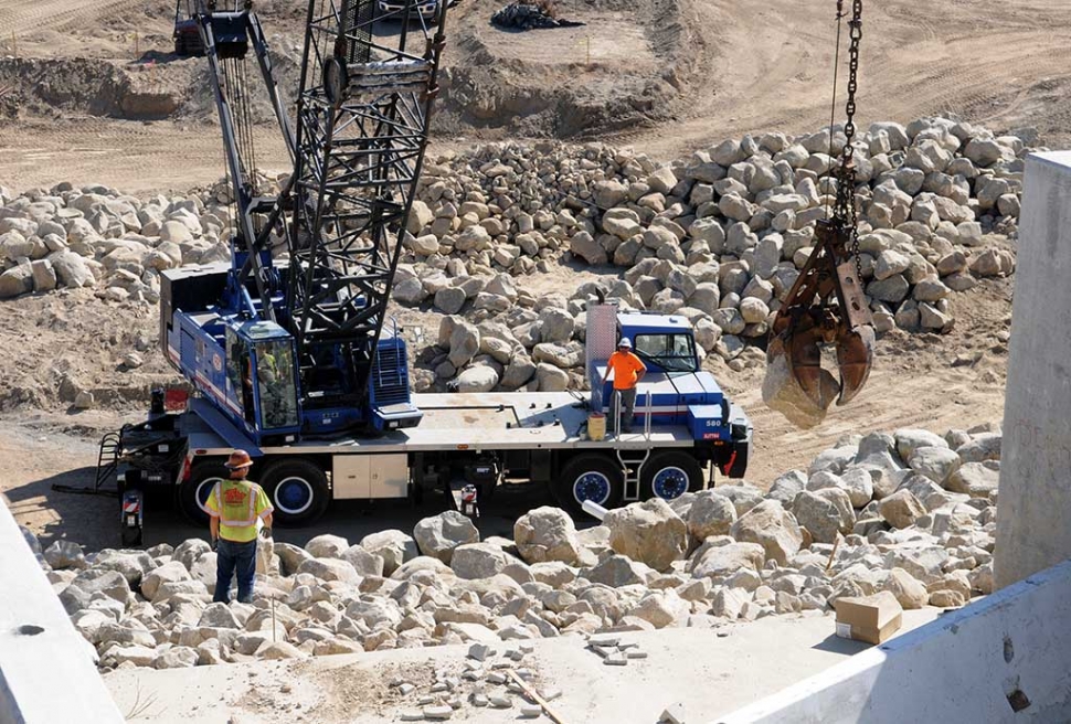 The rip-rap work being placed on the walls of the Poll Creek debris basin is moving quickly to completion. Watching the detailed work is fascinating. In different phases, rock is placed carefully, then concrete is poured over the face to seal crevices and make the face “waterproof”. The work is done with great care.