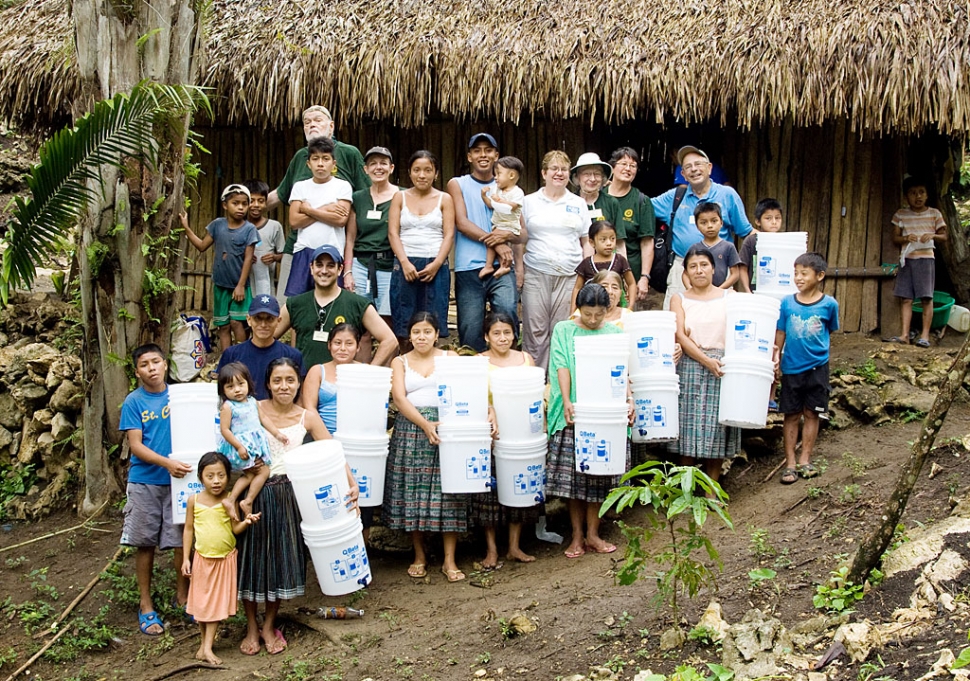 Q'eqchi' Maya community members gather with Rotarians who delivered and assembled water filters in their remote river village near Livingston, Guatemala.