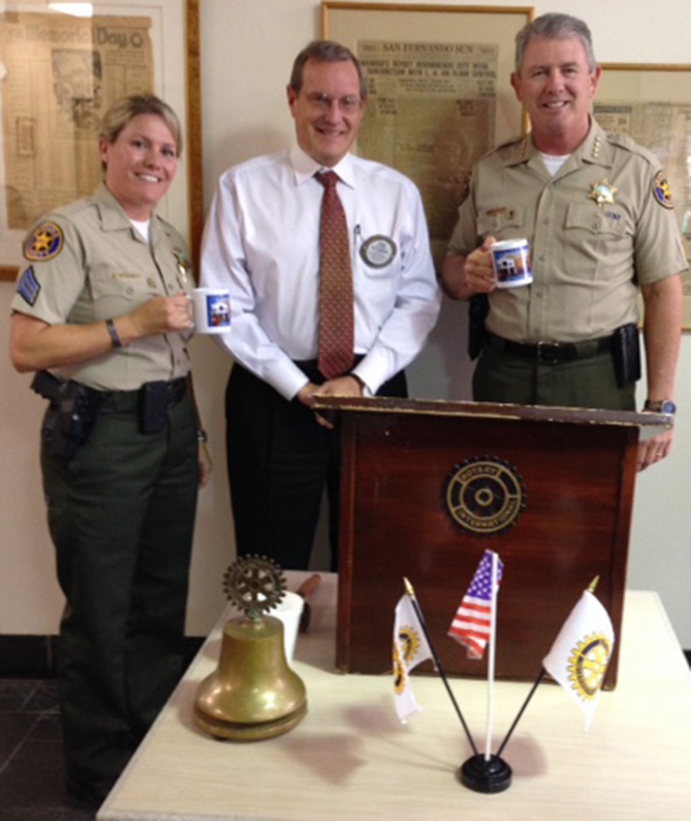 Sergeant Denise Sliva, President-Elect Kyle Wilson and Sheriff Geoff Dean. Sheriff Geoff Dean presented a program for the Rotary Club. He informed the Club about the new improvements to the Fillmore Station and about the excellent job done by the Pharmaceutical Crime Task Force. He also discussed the positive effects of the body worn cameras, such as less citizen complaints. He showed photos of the Unmanned Aerial Vehicle and explained how much it has helped with search and rescue and hasmat situations.