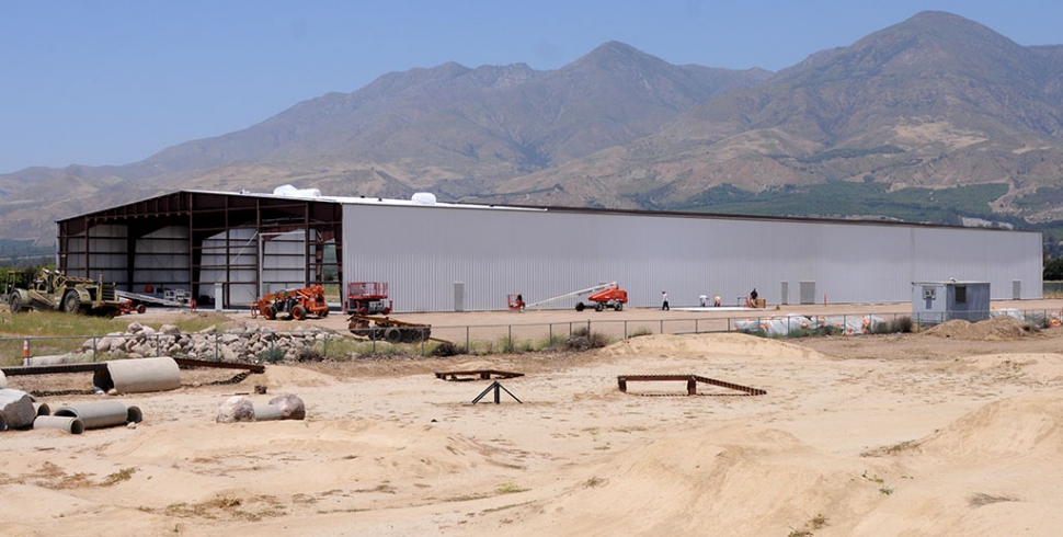 When you are entering Fillmore from the west, and you first see it, it’s an impressive site. The private heliport maintenance and repair facility for helicopters stretches from River Street to the edge of the Santa Clara River at D Street. The hangar measures 67,872 square-feet. Rotorcraft Support Inc. and The Guardian are part of the Fillmore Business Park Master Plan and construction of the facility is moving along, including parking spaces and retaining walls. Phase 2 consists of constructing a 45,066 SF hangar for a future undetermined tenant. The businesses would like to be allowed to operate from 7:00 a.m. to 6:00 p.m. Monday through Friday and from 7:00 a.m. to 12:00 p.m. on Saturdays with allowance to perform work on Sundays during times of emergencies. The project site is 10.52 acres and can accommodate one landing pad with eight (8) helicopter parking areas. The flight paths will occur along the Santa Clara River with the helicopters approaching the site from a southerly direction. The flight paths will not be over the residential areas of Fillmore.