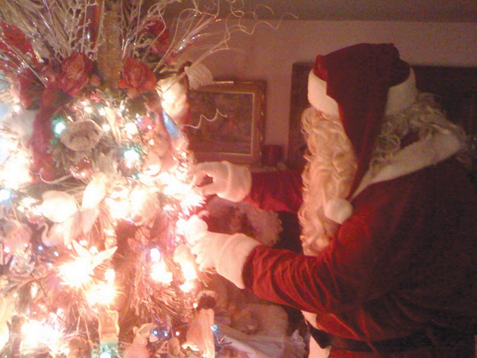 Santa puts a last minute touch on the Christmas tree.