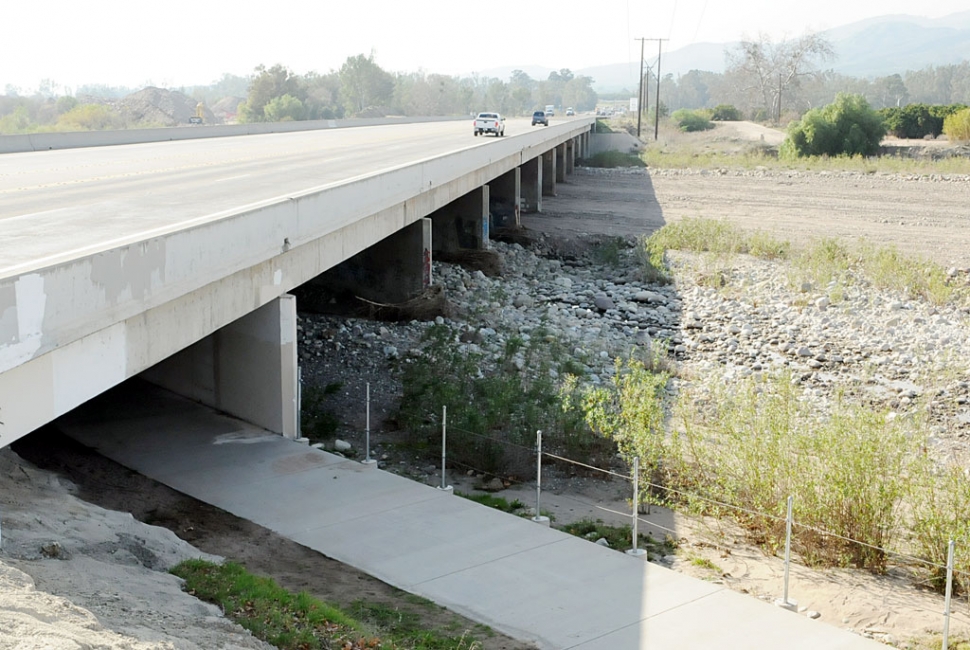 A westward view of the Fillmore bridge crossing Sespe Creek shows the recent cleanout of rock and debris at the center. Upland Rock has completed the work of grading and removing debris which accumulated over the years at the center of the bridge. The rock presents a flood threat for the western part of the city.