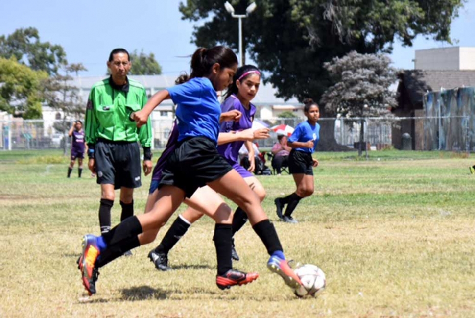 Forward Marlene Gonzales (front) races by the opposing player as Jadon Rodriguez (back) awaits a crossing pass to take a shot. Photo by Martin Hernandez.