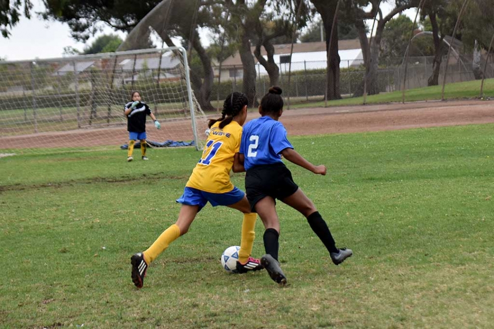 Battle – California United player Jadon Rodriguez leans in to the defender as she fights her way towards the goal.