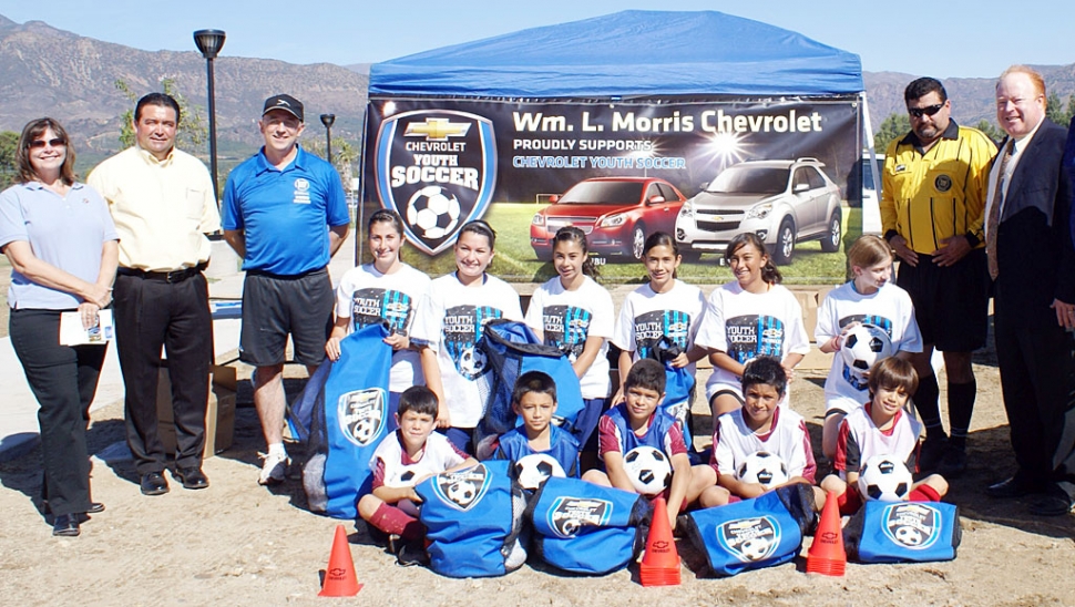 William L. Morris Chevrolet and Fillmore AYSO are participating in a fundraiser to help raise money for AYSO. Players will be selling raffle tickets for a chance to win a car. All proceeds from the raffle will go directly to Fillmore AYSO. Pictured above (l-r) standing: Mayor Pro-tem Gail Washburn, Fermin Sarabia, Perrie Gerardy, Greg Aguilar, and Chap Morris. The soccer players in alphabetical order: Diana Aguilar, Amanda Armstrong, Adrian Beserra, Marcos Cardenas, David Dunham, Kendra Magana, Adrian Martinez, Raylene Martinez, Jovanni Olivera, Grace Topete, and Sarah Vollmert. For more information regarding the raffle please contact Greg Aguilar. Photo courtesy Sespe Sun.