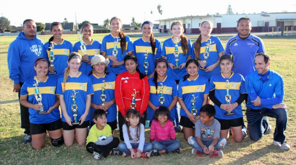 Players and coaches, (l-r) (bottom row) Rachel Rivera, Sarah Volmert, Lizette Martinez (Nena), Salma Gomez, Ana Rincon, Jocelyn Munoz, Caroline Esquivel, Coach Willy, (top row) Coach Homer Martinez, Grace Topete, Reylene Martinez, Emily Garnica, Esmeralda Murillo, Vanessa Estrada, Ryan Nunez, Coach Arnold Munoz. Little cheer squad: Isaac Martinez, Maddie Munoz, Mia Munoz, Adrian. Players missing from photo: Briana Santa Rosa, Denise Vasquez, Betty Morales.