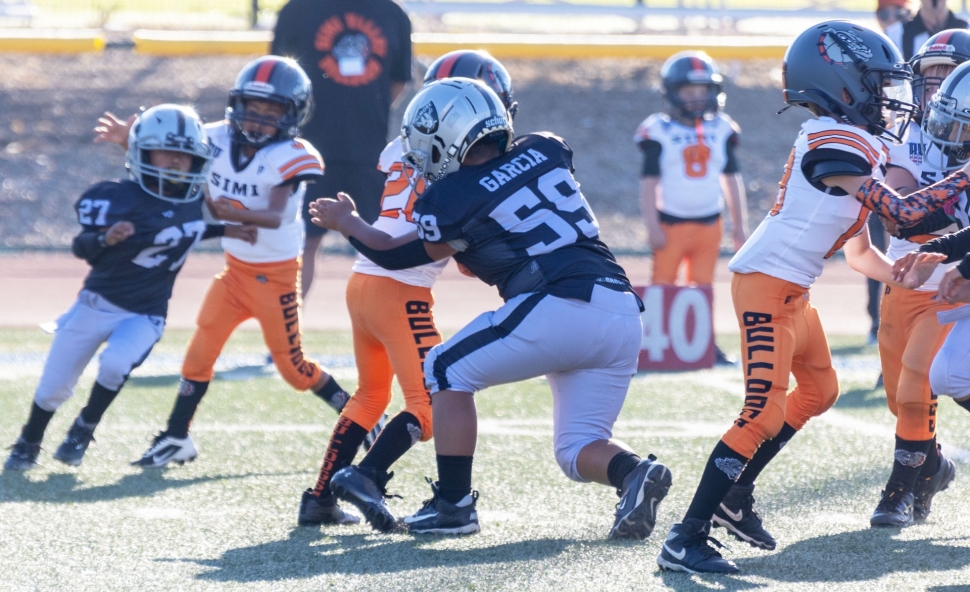 Pictured is Raiders Mighty Mites Black #59 tackling a Simi Valley Bulldog player stopping him cold. Photo credit Crystal Gurrola.