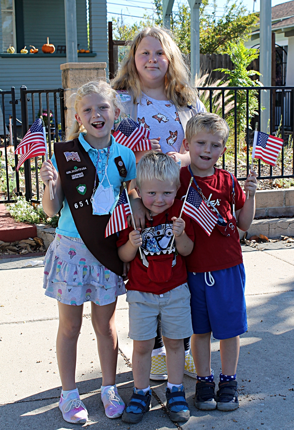 Emma, wearing her Fillmore with Girl Scout Troop 6510 sash, Fiona, James, and William are all smiling with their flags. They walked up and down Central Avenue before the parade and handed out American flags to parade attendees to wave as the Veterans took their cruise downtown.