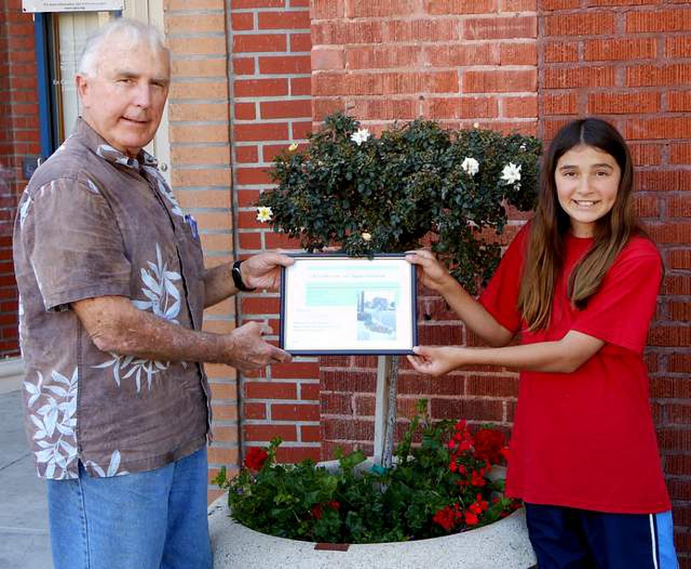 Victoria Pace, a 6th grader at Fillmore Middle School, receives a certificate of appreciation for sponsoring and helping replant a large Central Avenue pot as part of Vision 2020, Civic Pride Committee’s downtown revitalization project. Bill Dewey, a Civic Pride member, makes the presentation.