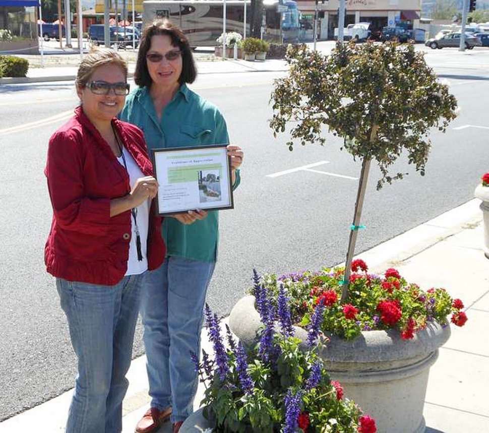 Ari Larson, representing Soroptimist of Fillmore, receives a certificate of appreciation from Civic Pride member, Linda Nunes, for the two Central Avenue pots that they helped replant.