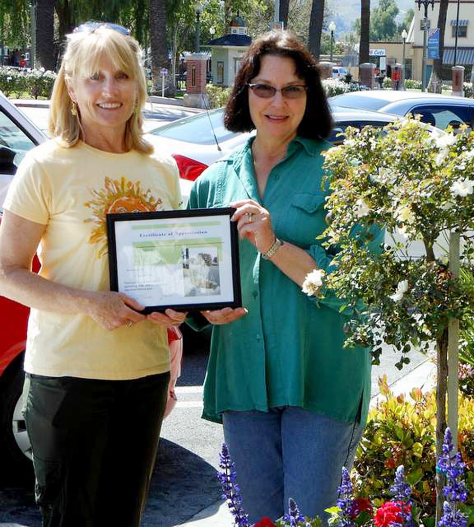 Janet Foy, who sponsored and replanted three Central Avenue pots receives a certificate of appreciation from Civic Pride Committee.