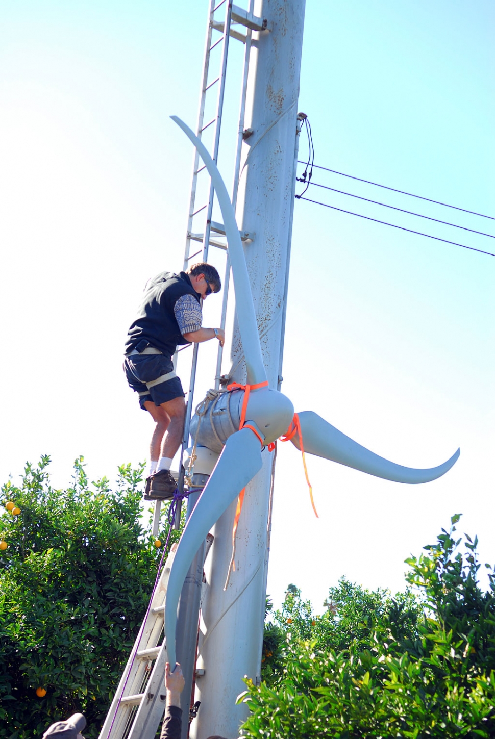 Installation of a new wind generator takes place under the watchful eyes of local farmer Bob Hammond. Converting his old orchard wind machine is expected to produce up to 500 kilowatts per month for the Hammond household. This is about as green as it gets.