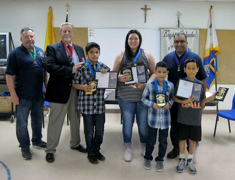 Six boys and girls from Fillmore, Ca. ages 9 to 14, were named local champions of the 2016 Knights of Columbus Free Throw Championship, and have earned the right to compete at the district level. St Francis of Assisi Council 8800 in Fillmore sponsored the local competition at the Fillmore Boys and Girls Club on Saturday, January 30, 2016. All youngsters ages 9 to 14 were eligible to participate. Natalie Velasco was the 9-year-old girls’ champion. Sophia Velasco was the 10-year-old girls’ champion and Makhi Hooker was the winner of the 10-year-old boys’ division. In the 11-year-old bracket, Nathan Perez was the boys’ champion. The Twelve-year-old winner in the boys’ division was Javier Benito Avalos. The 13-year-old girls’ division was won by Elsa Ramirez. Each contestant attempted 15 free throws in the contests. All ties were settled by successive rounds of five free throws per contestant until a winner emerged. Each of these winners will compete in the district competition to be held on Sunday February 28th at 1:00 pm at the Boys and Girls Club 200 Casey Rd , Moorpark Ca. 93021 with an eye toward moving on to the state and international levels. Front row Benito Avalos, Makhi Hooker, Nathan Perez Back Row Youth Director John Holladay, district Deputy Joe Lee, Elsa Ramirez, Grand Knight Mark Cervantez.