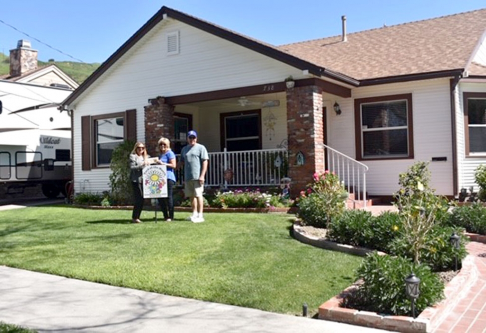 (l-r) Ari Larson of Fillmore Civic Pride presenting Janet Schrock and Rod Schrock with their certificate of $40 for winning March 2019 Yard of the Month. Photo courtesy Miranda Alonzo.