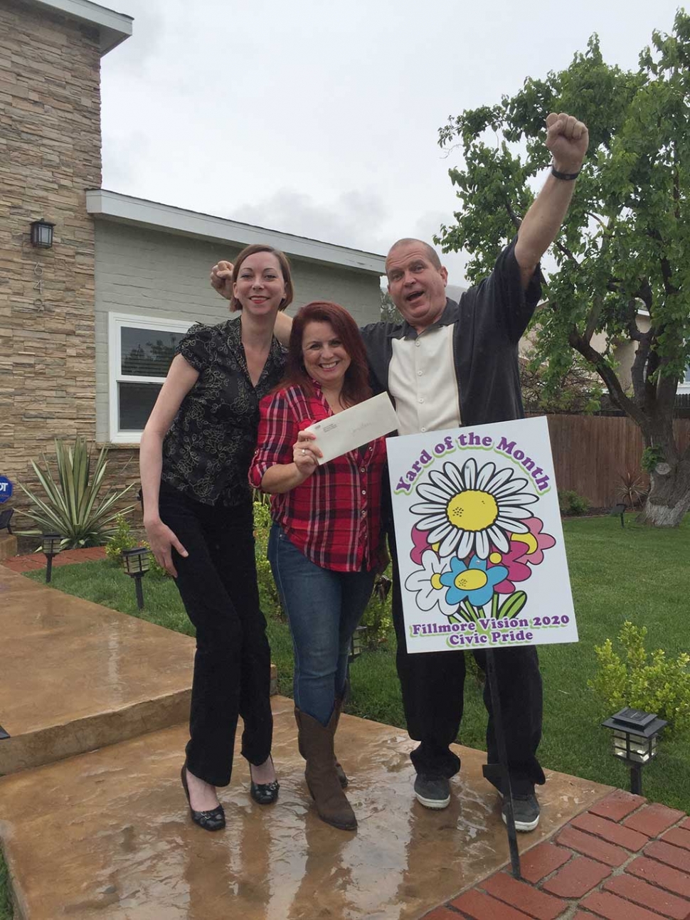 Congratulations to Joe Beebe & Grace Kline, left, for receiving the Yard of the Month Award for April! (As you can see, They are EXCITED!) Amongst the many plants you will find in front of their beautiful home are: Mulberry Tree, Avocado Tree, Japanese Maple, Calla Lillies, Birds of Paradise, Dr. Seuss Plant, Japanese Boxwood and Gorgeous Red Velvet Roses (from Otto & Sons). Please drive by 649 4th Street, cross street A St. to view their beautiful cared for yard by Reyes Landscaping! Thank you to Otto & Sons for their generous gift to the winners of $40. Fillmore Chamber Rep Theresa Robledo presents Civic Pride Vision 2020 Award for Yard of the Month.