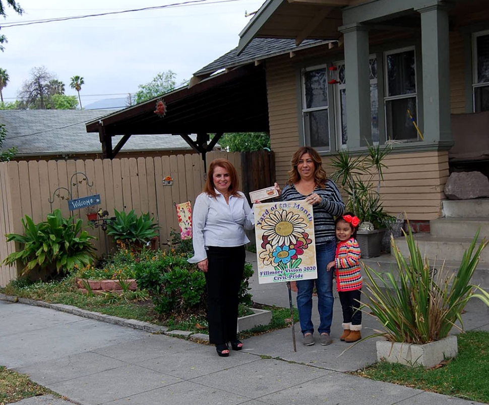 Theresa Robledo with Civic Pride Vision 2020 presents Yard of the Month to Jesse & Deana Camarillo and their beautiful granddaughter, Aleana! Congratulations!  Please drive by 341 Sespe to view.  The Camarillo home is located on Sespe, where you will find Ferns, Daisies, Pittosporum Tobira, Phormium Hybrid, Pennisetum Setaceum, Roses, Poinsettias along a beautiful tree lined street.  They live in a California Craftsman, which in my opinion makes their garden even more appealing!  Thank you to Otto & Sons Nursery for their generous gift certificate to the Camarillo Family!